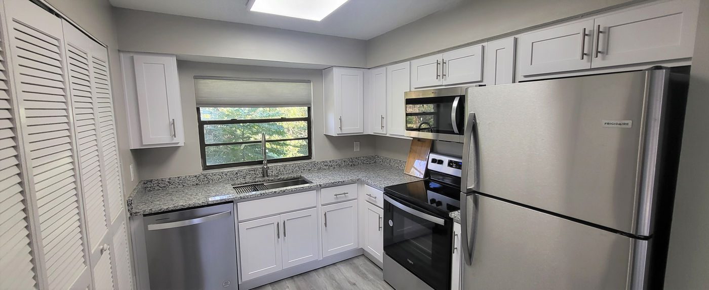 Kitchen with white cabinets, speckled gray counters and stainless appliances at Hyde Park