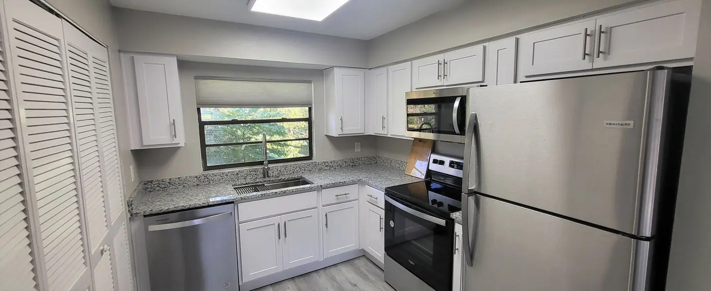 Kitchen with white cabinets, speckled gray counters and stainless appliances at Hyde Park