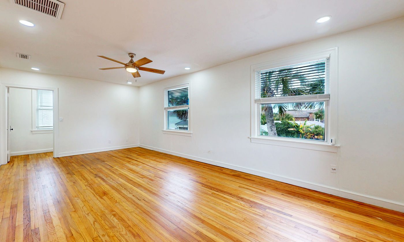 Living room with honey-toned wood floors at Neptune Beach