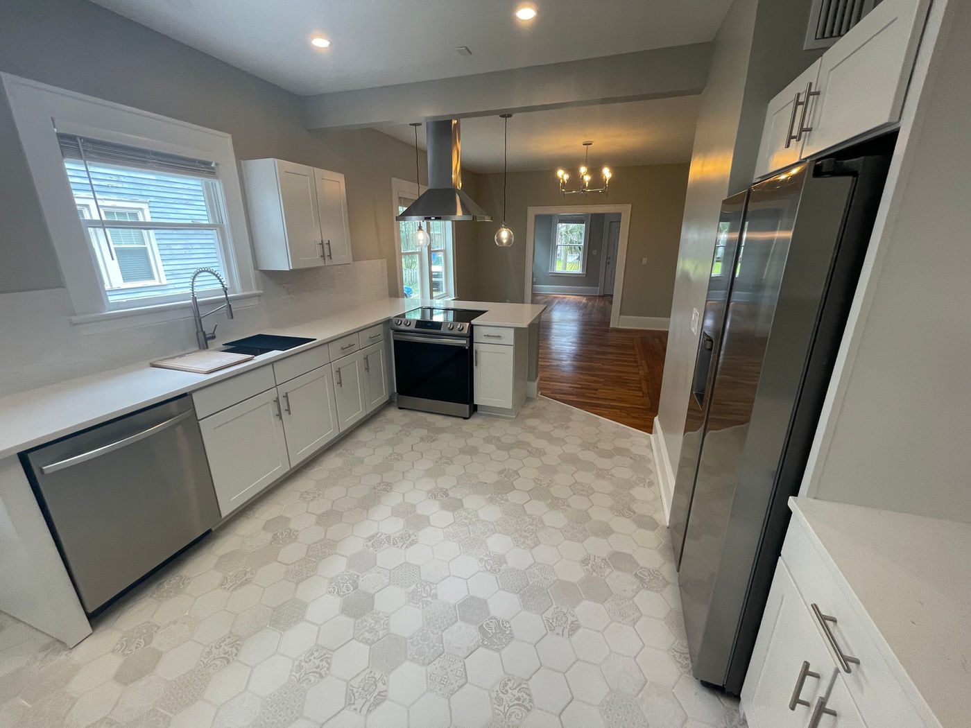 Kitchen with hexagon tile, white cabinets and stainless appliances at Riverside
